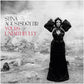 Black and white album cover featuring a woman in a black gown with puffed sleeves standing in a rock