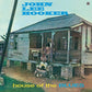 Album cover showing a weathered wooden house on stilts with a man seated on the porch