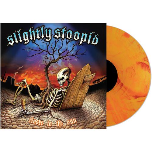 Yellow and orange marbled vinyl record next to album cover featuring a skeleton in a desert