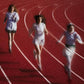 Three women running on a red track with white lane lines