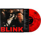 Red and black marbled vinyl record next to its album sleeve featuring blurred street photography