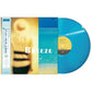 Translucent blue vinyl record partially removed from album sleeve with beach artwork