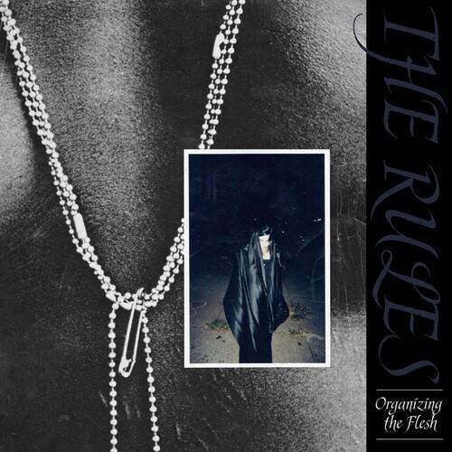 Black vinyl album cover featuring a silver ball chain necklace with a safety pin and a dark inset ph