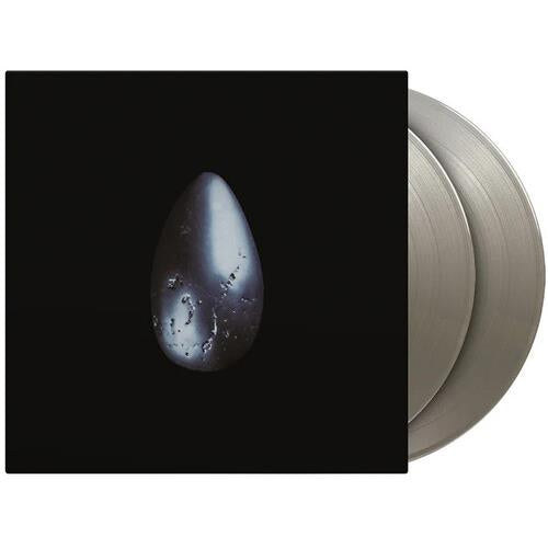 Silver colored vinyl record partially removed from black album sleeve featuring a single teardrop gr