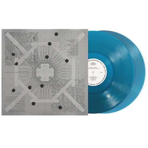 Aqua colored vinyl record next to a gray album sleeve with geometric artwork
