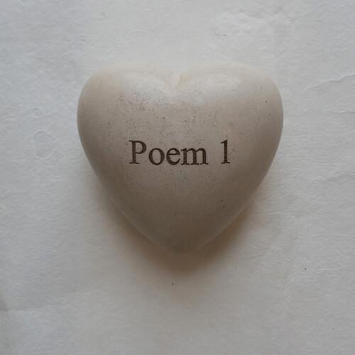 Heart-shaped stone with the text "Poem 1" engraved on the front