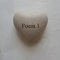 Heart-shaped stone with the text "Poem 1" engraved on the front