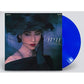 Clear deep blue vinyl record partially removed from a black album sleeve featuring a woman in a blac