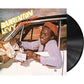 Vinyl record sleeve showing a man in a red cap leaning out of a car window exchanging cash
