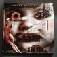 Surreal collage album cover featuring a face with torn paper fragments and a muscular figure