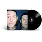 Black vinyl record partially removed from blue album sleeve featuring two illustrated faces
