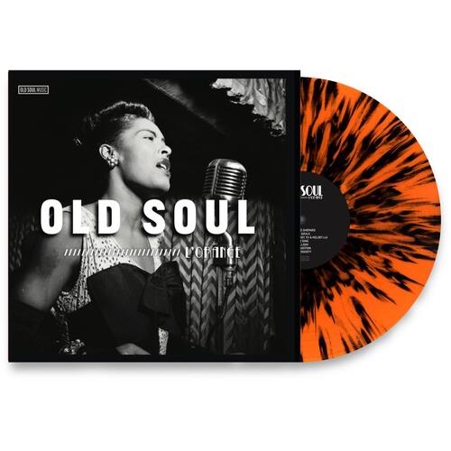 Orange and black splatter vinyl record next to a black and white album cover featuring a woman singi