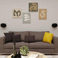 Pair of black wall-mounted speaker brackets holding oval speakers on either side of a sofa