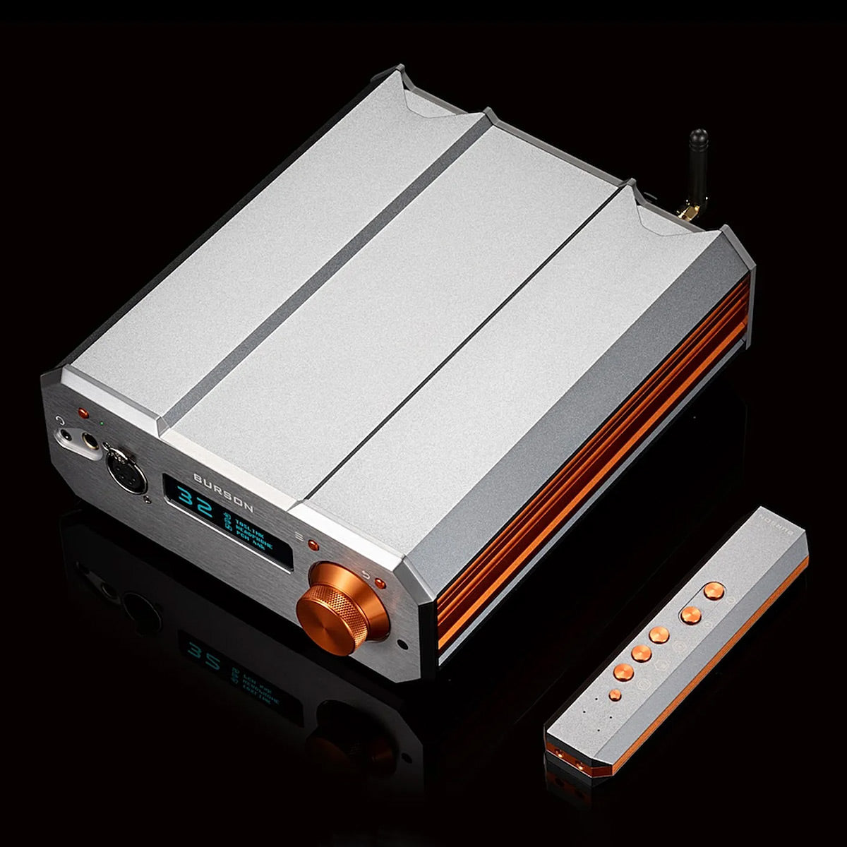 Silver and orange desktop DAC and headphone amplifier with a digital display and matching remote