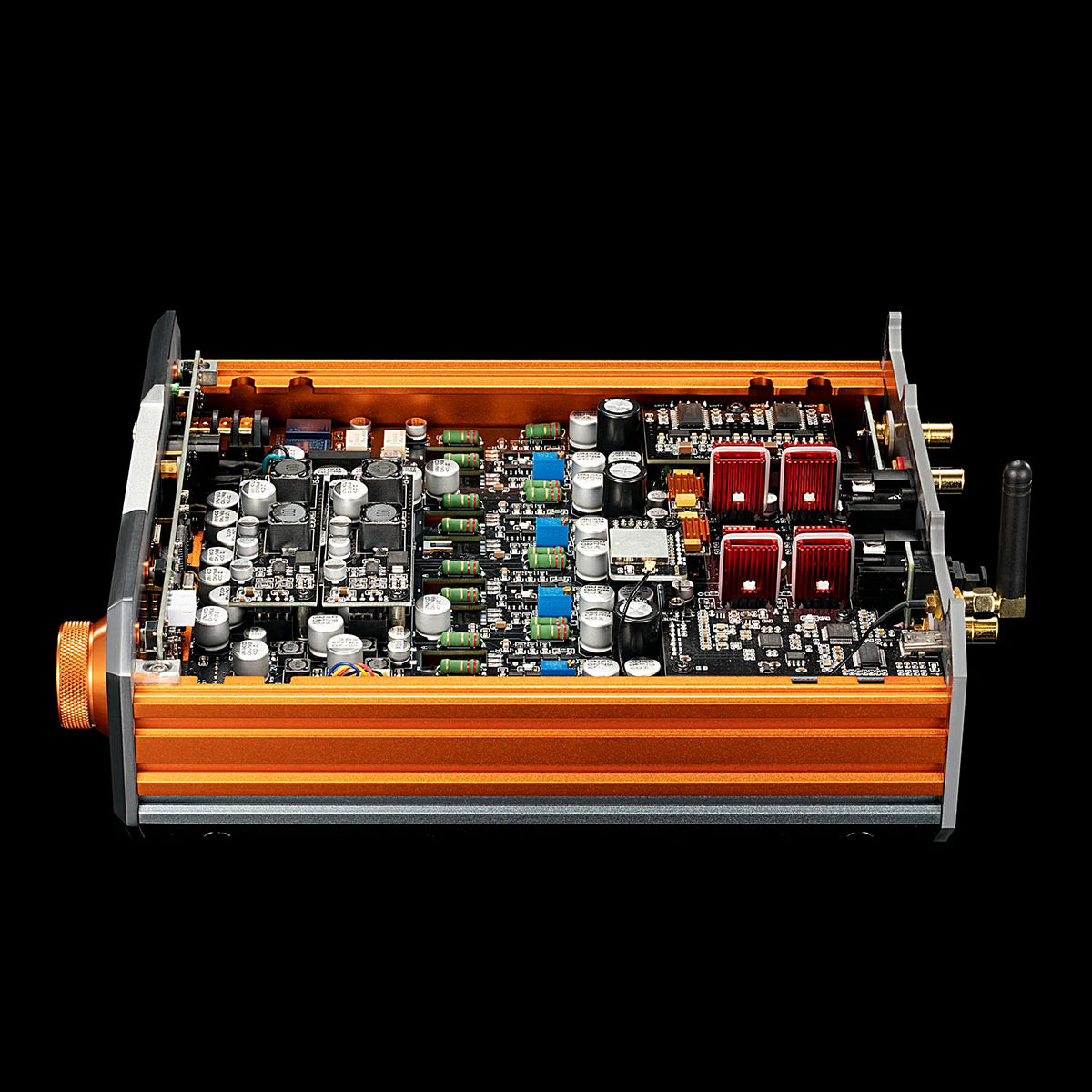 Open chassis view of a copper and silver audio amplifier with exposed circuit board and red heatsink