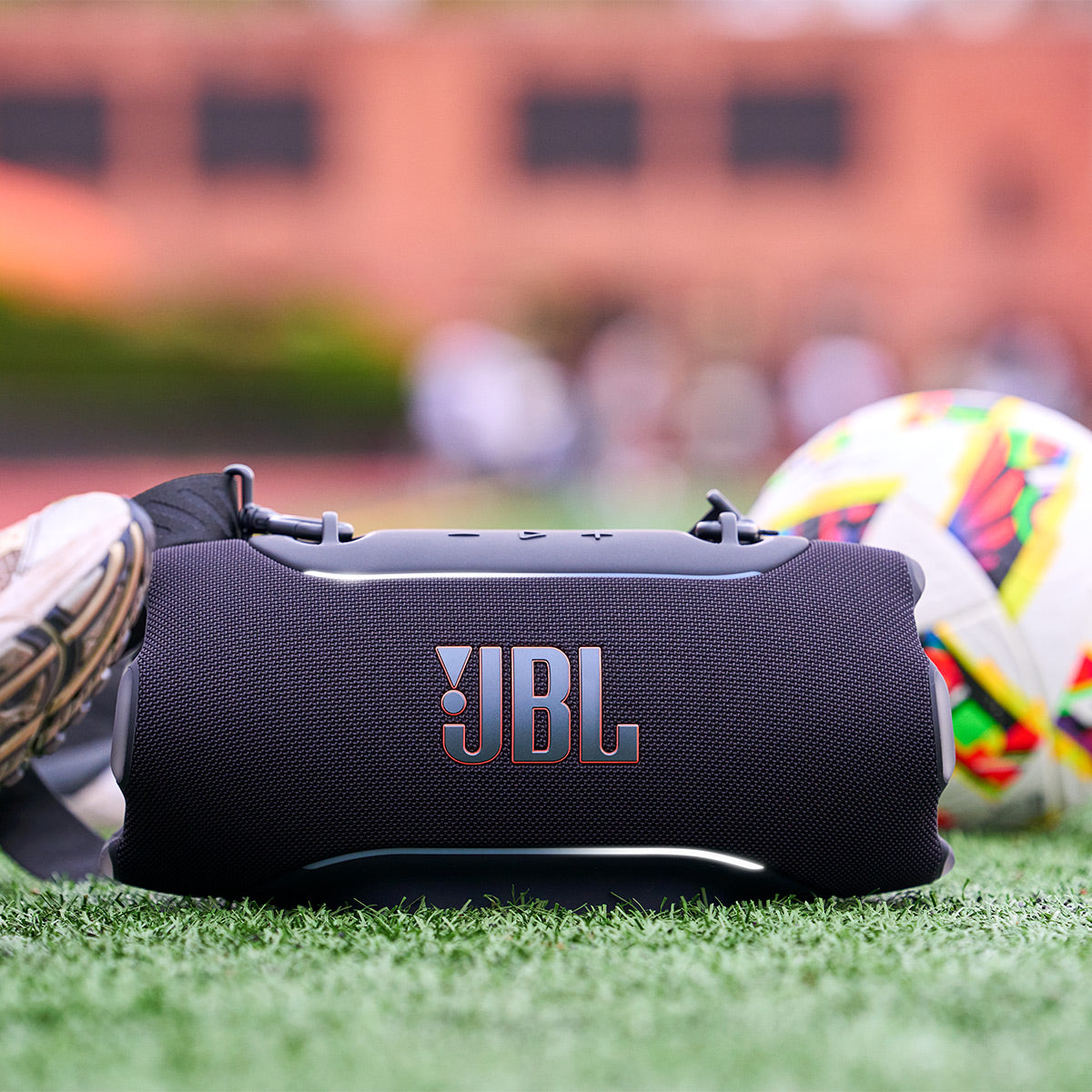 Black portable Bluetooth speaker with orange logo and top control buttons