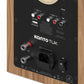 Back panel of a matte walnut bookshelf speaker with RCA, optical, and USB power ports