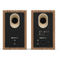 Pair of matte walnut bookshelf speakers with rear-facing ports and multiple input connections