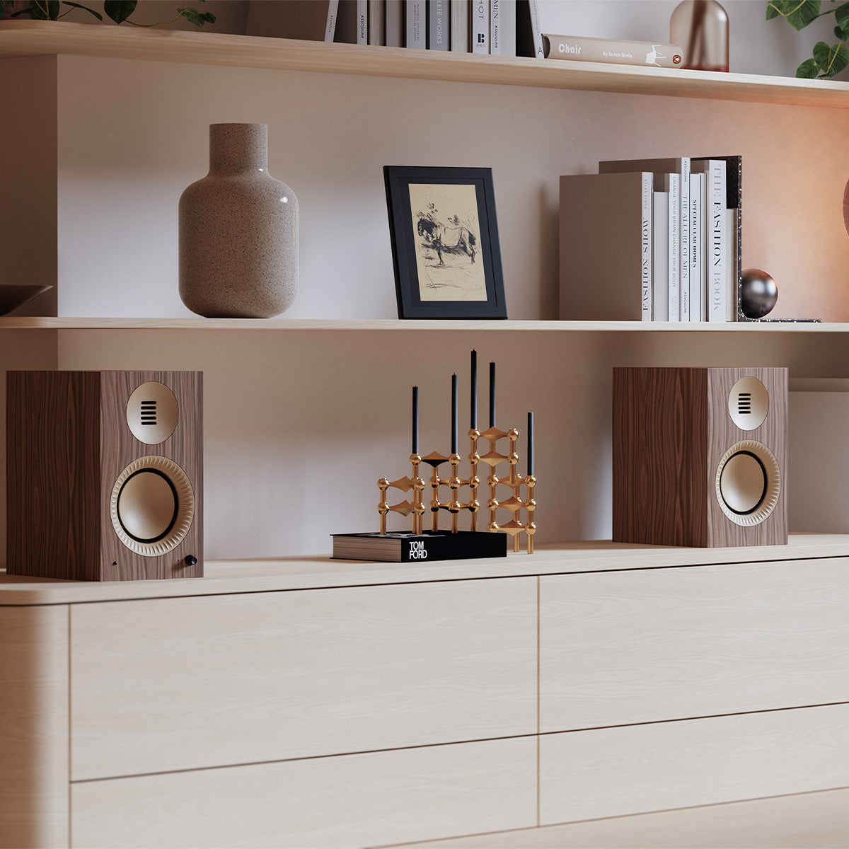 Pair of matte walnut bookshelf speakers with cream-colored drivers and gold accents