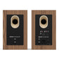 Pair of matte walnut bookshelf speakers showing rear panels with bass ports and input connections