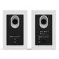 Matte white bookshelf speakers with rear-facing ports and multiple input connections