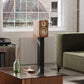 Matte walnut bookshelf speaker with a cream woofer and ribbon tweeter on a black stand
