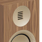 Matte walnut bookshelf speaker with a circular gold-tone tweeter and a textured woofer