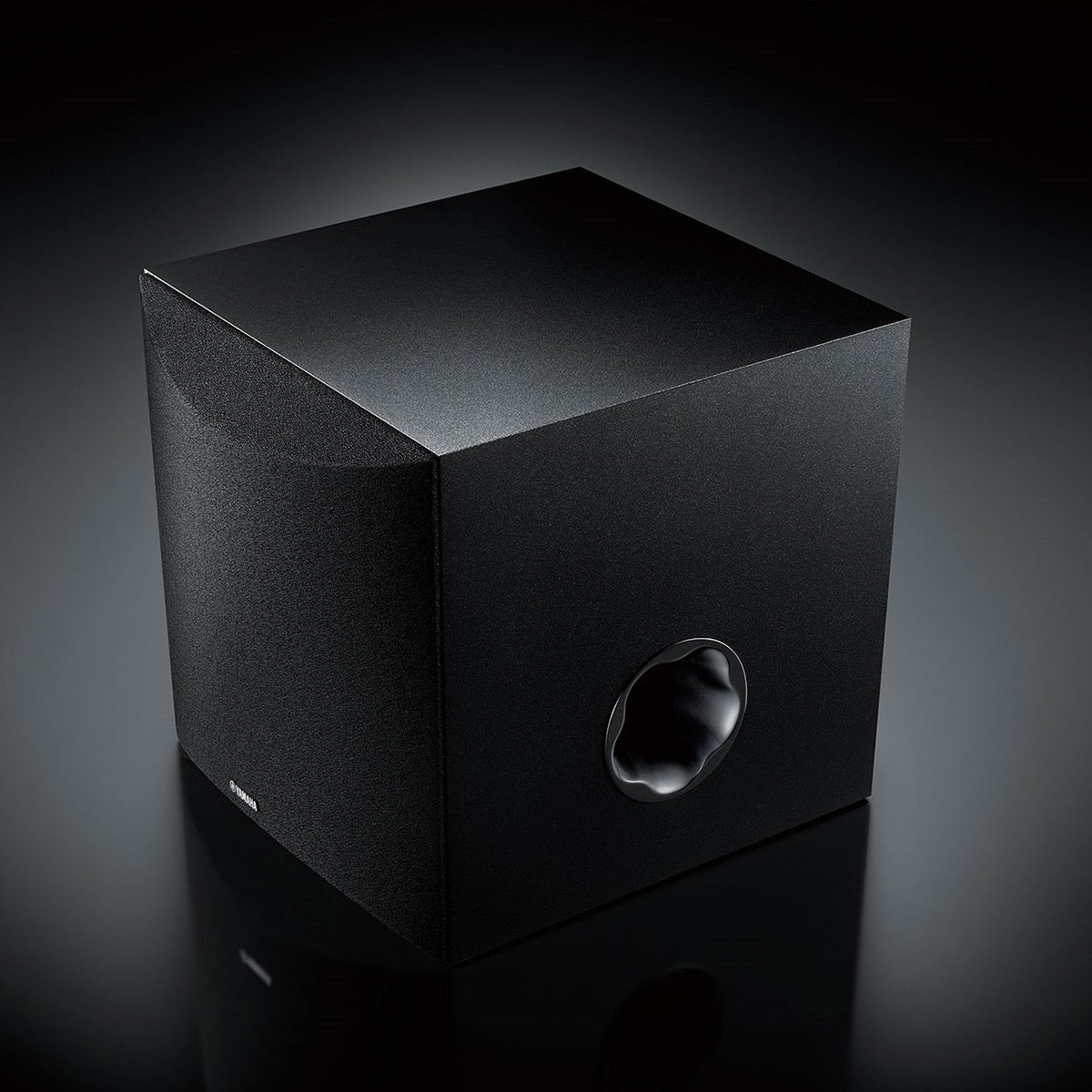 Black cube-shaped subwoofer with a front-facing circular port and textured finish